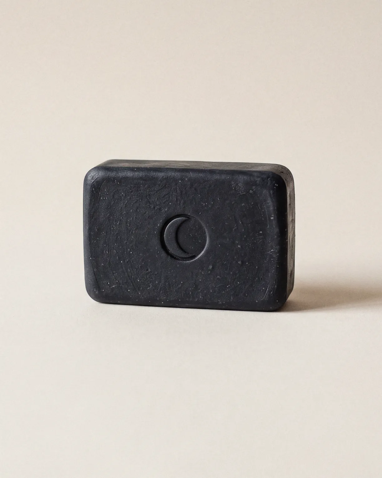 the basalt bar, charcoal soap pressed with a moon