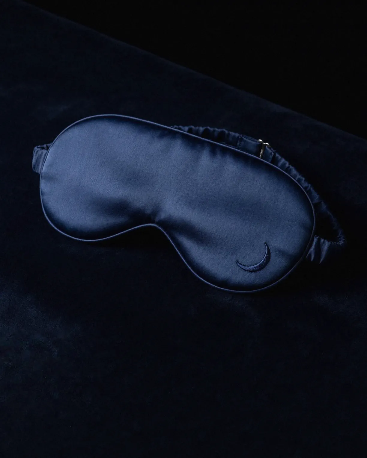 the night mask in navy mulberry silk, on dark velvet