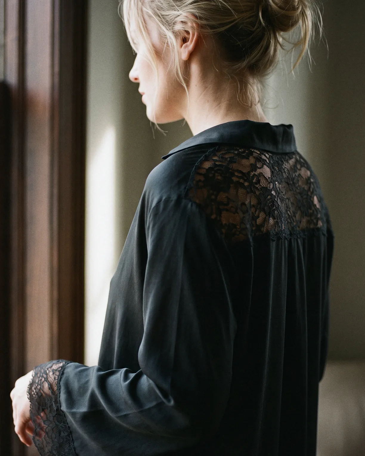 the night shirt, black silk with lace at the yoke and cuffs, worn at a window