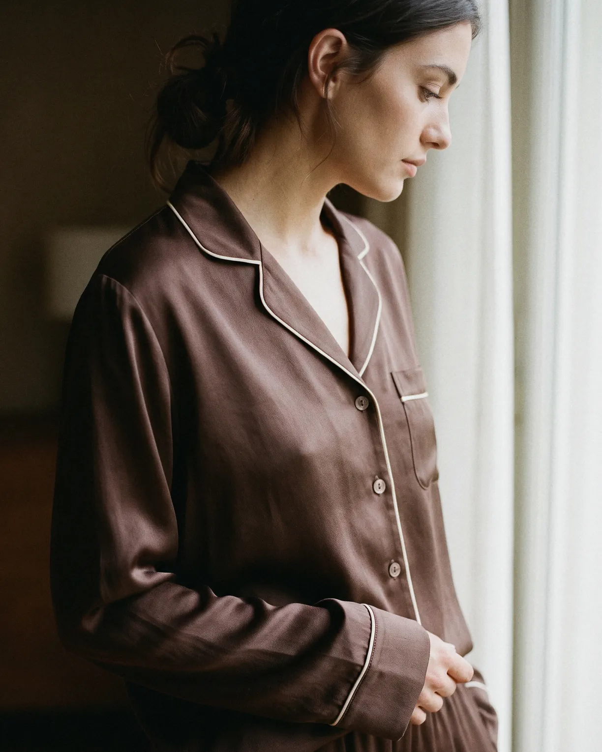 the silk pajamas, mocha silk piped in cream, worn at a window