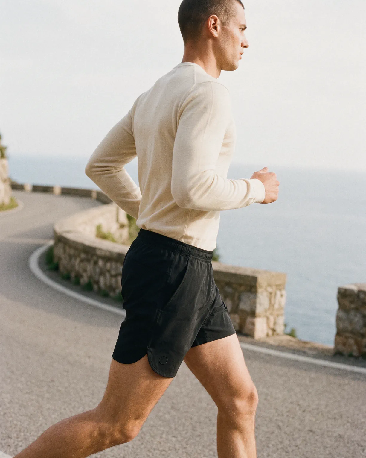 the water shorts in black, worn running on a coast road above the sea